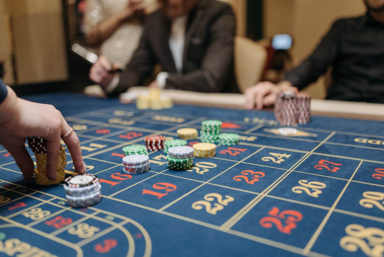 Tangan menaruh chip pada meja roulette kasino